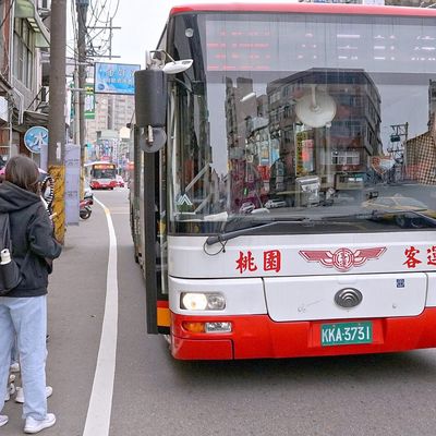 公車停靠站牌，乘客在旁等候